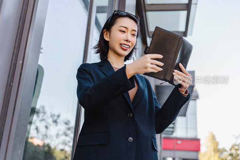 成功的女经理走在城市的街道上。