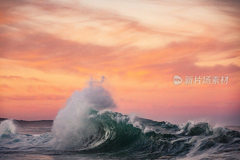 海浪与戏剧性的金色天空碰撞