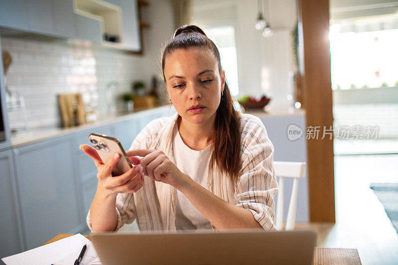 年轻女子在家里用笔记本电脑查看自己的财务状况