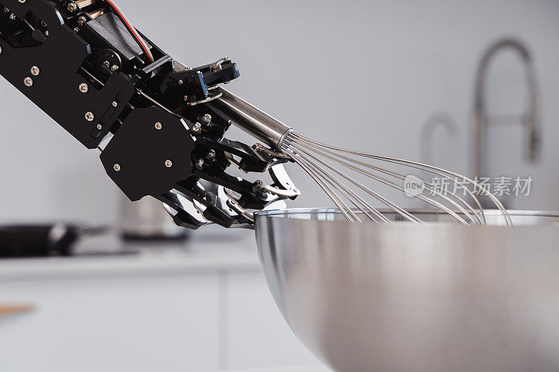 真正的机械手和不锈钢打蛋器。机器人过程自动化的概念。