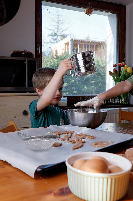 一个孩子在家里种面粉和准备面团