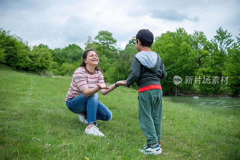 阿姨和侄子一起在公园的操场上玩耍。