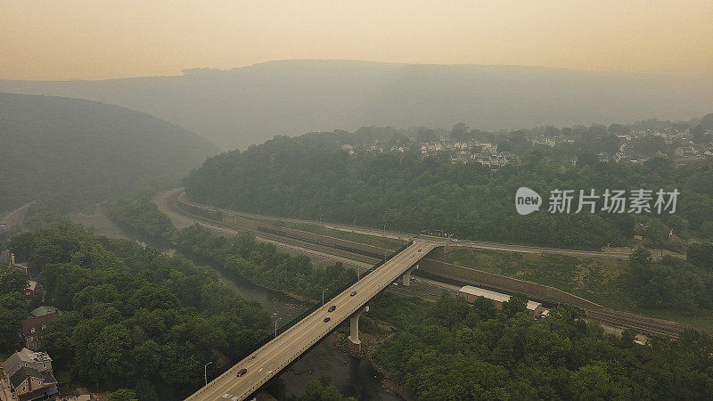 在阿巴拉契亚山脉，河流上方的高架道路被野火的阴霾所遮蔽。宾夕法尼亚州吉姆索普波科诺斯的米斯蒂利哈伊河谷。鸟瞰图