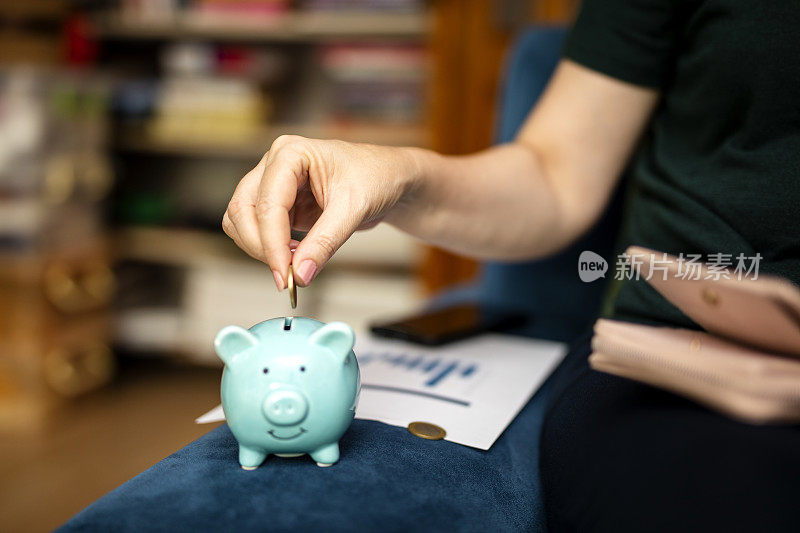 女人用手把硬币放进小猪里存钱