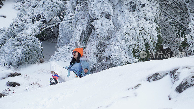 一个女人在寒冷的天气里穿行于白雪覆盖的山林之中