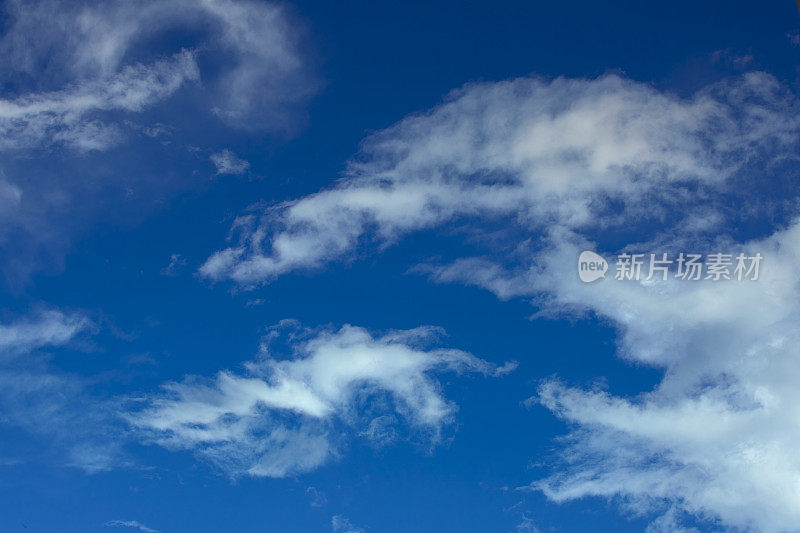 蓝蓝的天空中，云引人注目。多层云从远处看是由黑云和白云组成的。