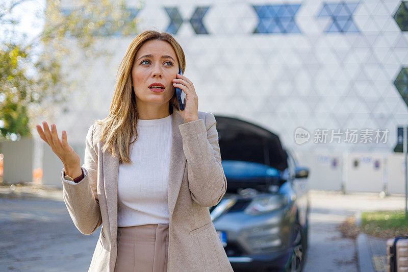 一名沮丧的妇女，她的车在路边被撞坏了