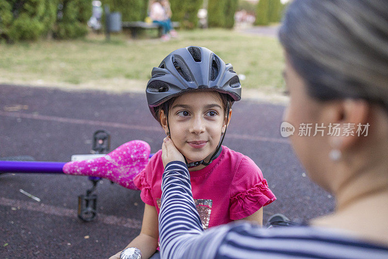 成功地骑上自行车后，妈妈抚摸女儿的脸颊
