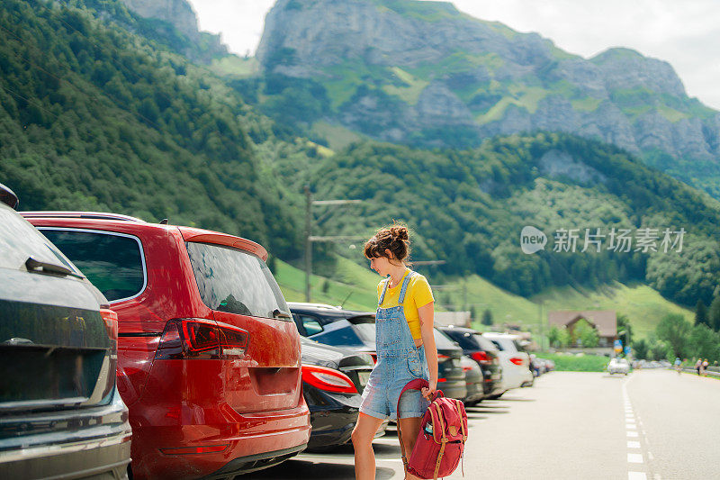 一名女子在瑞士阿尔卑斯山徒步旅行后把背包打包到车上