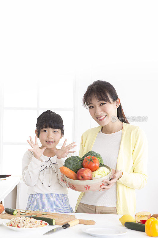 妈妈跟女儿拿着蔬菜