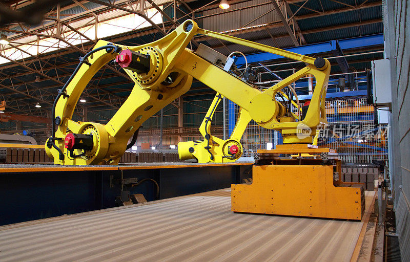 自动化生产线上的机器人在传送带上拾取砖块