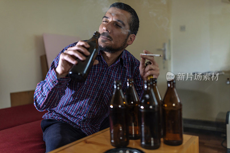 年轻悲伤的醉酒男子喝啤酒和酒精感到浪费，孤独和绝望的痛苦和情绪压力。人与酗酒、上瘾和男人抑郁的概念。