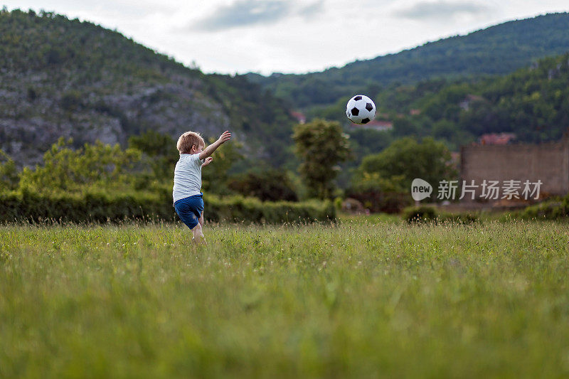 小男孩在操场上踢足球