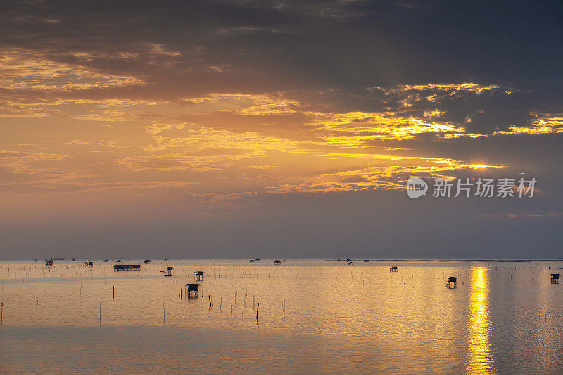 日落的渔民船和鱼笼子在海水中，泰国