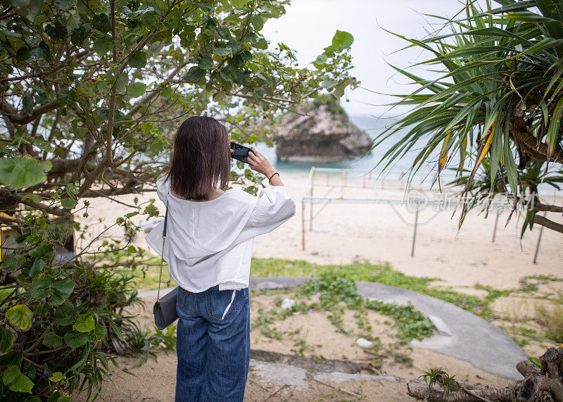 年轻女子拍摄美丽的度假海滩