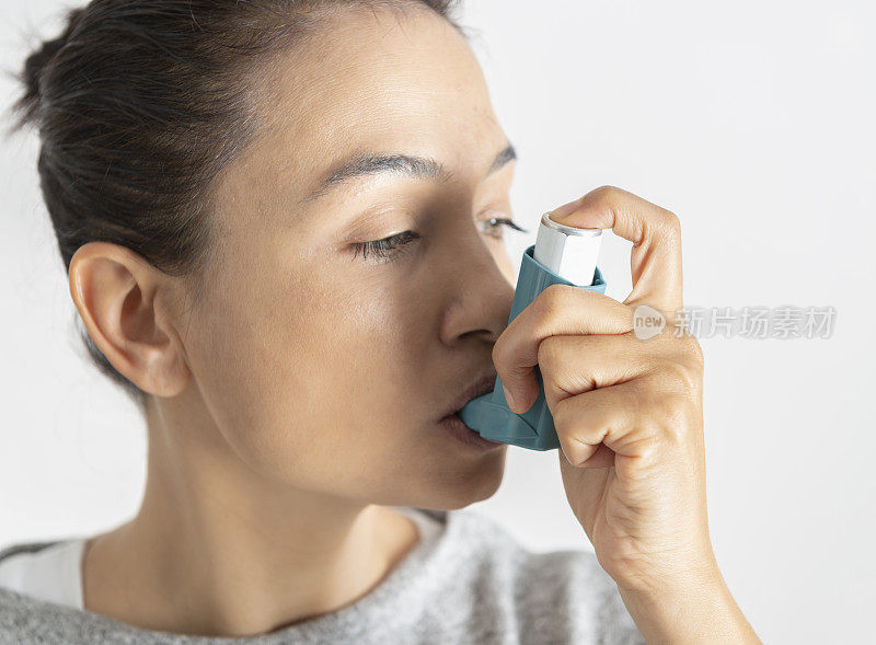 使用哮喘吸入器的女人