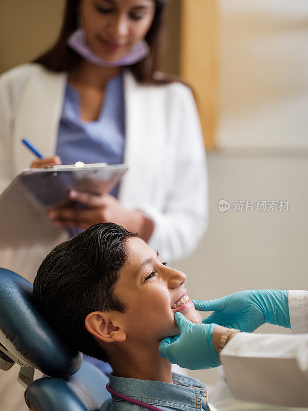 拉丁男孩在看牙医时露出牙齿