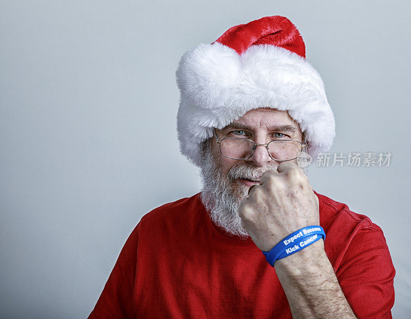 癌症幸存者圣诞老人展示支持癌症的腕带