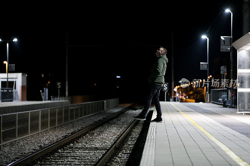 沮丧的人站在火车站向下看