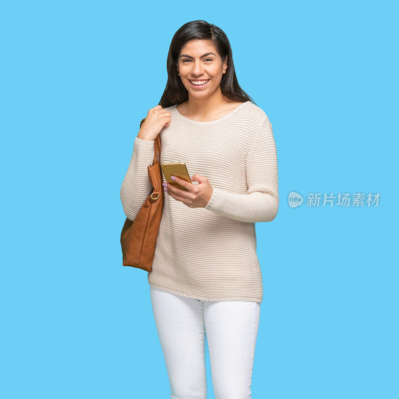 拉丁美洲和西班牙裔女性穿着毛衣，拿着钱包和使用智能手机