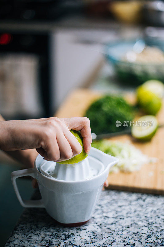 在厨房柜台上挤柠檬汁的女人