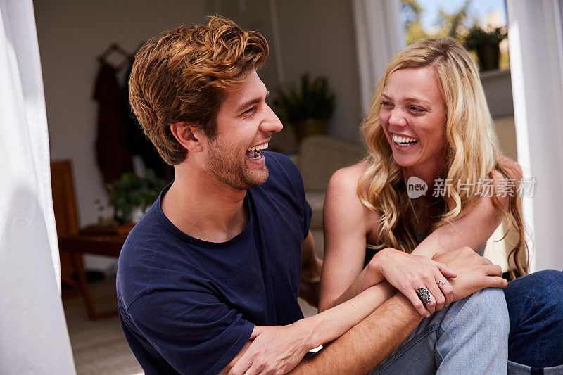 年轻夫妇在他们的院子里一起欢笑的夏天