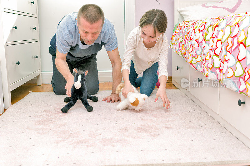疫情封锁期间，父亲和女儿在女儿卧室的地毯上玩耍，共度美好时光