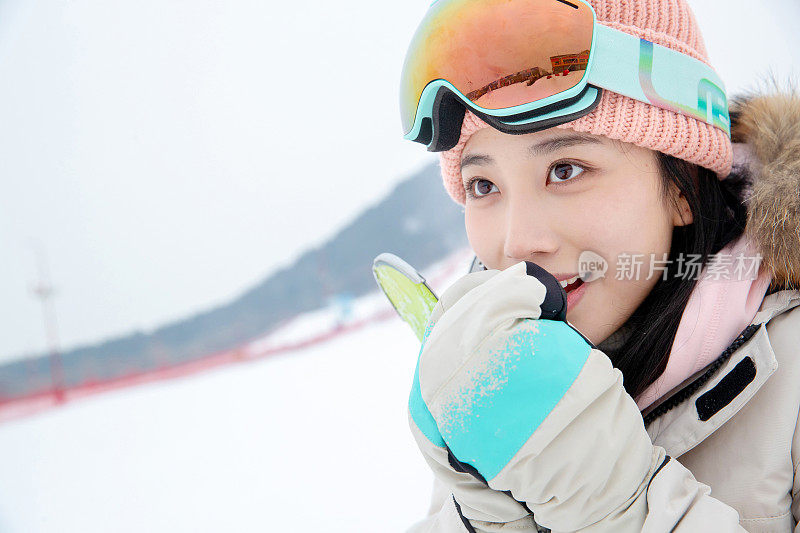 滑雪场上对着手哈气的青年女人