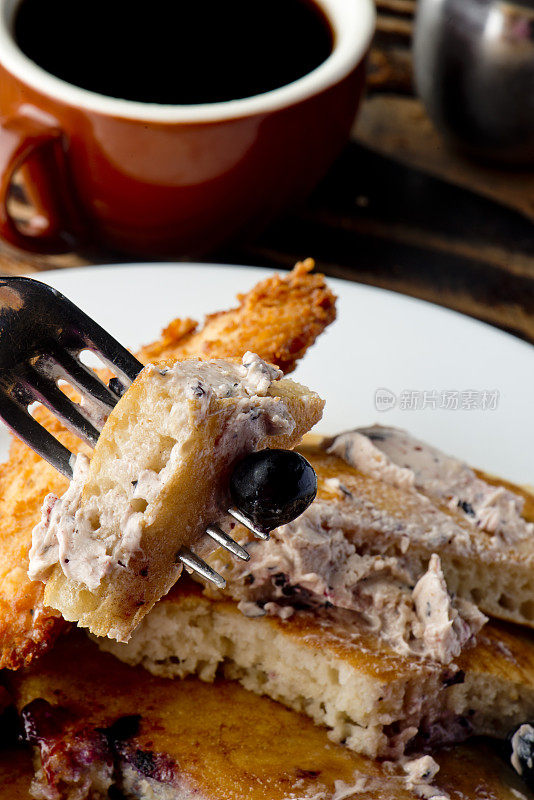 蓝莓酪乳煎饼配浆果黄油和脆脆的南方炸鸡。经典的美国早餐或早午餐的最爱。自制煎饼配黄油和枫糖浆。