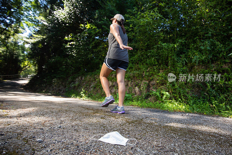 女慢跑者将口罩掉在地上