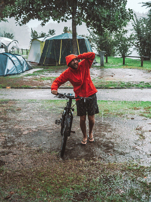 一名山地摩托车手冒着暴雨回来露营