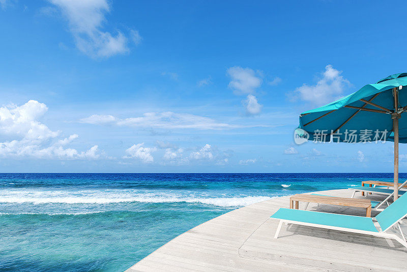 热带海边木质阳台阳台上的躺椅和阳伞