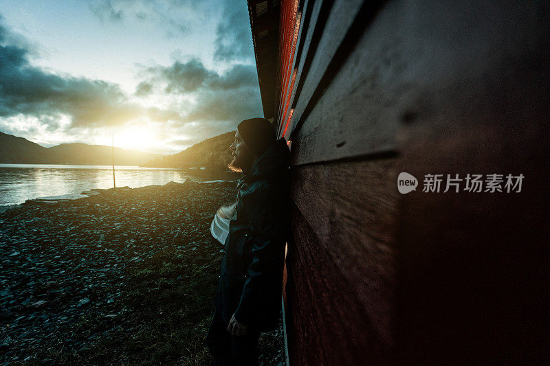 长着胡须的渔民肖像:晚上在峡湾边穿着雨衣