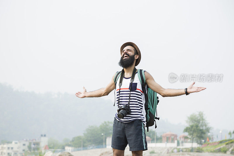 年轻的胡子男人摄影师在山车站:-库存照片
