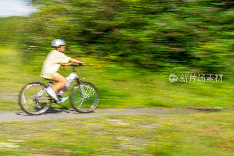 12岁的女孩在乡下骑自行车