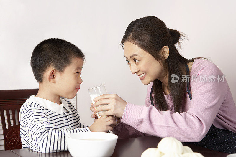 母亲给儿子喂牛奶