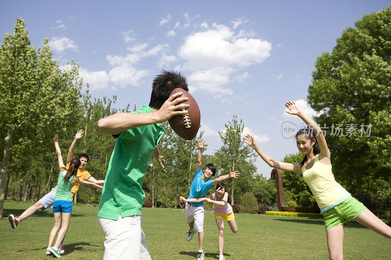年青人公园玩橄榄球