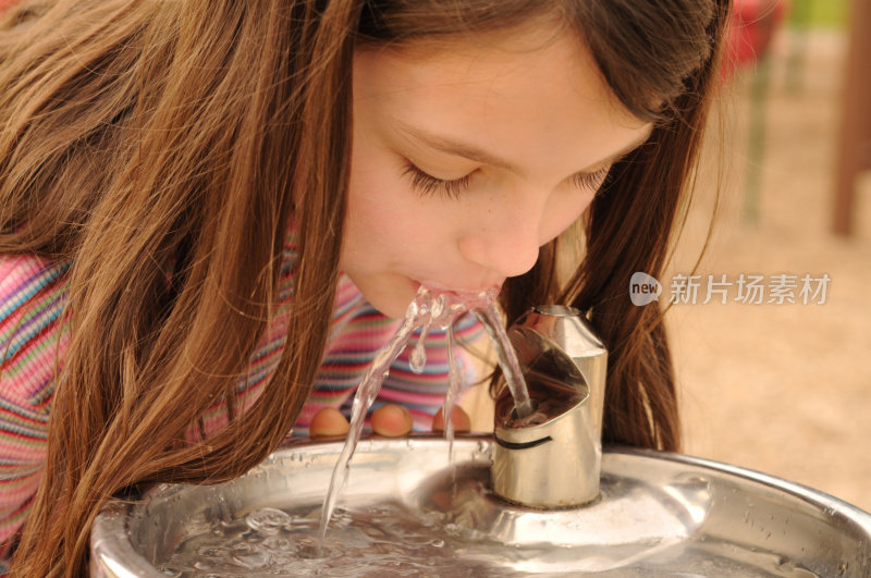 女孩在饮水机边解渴