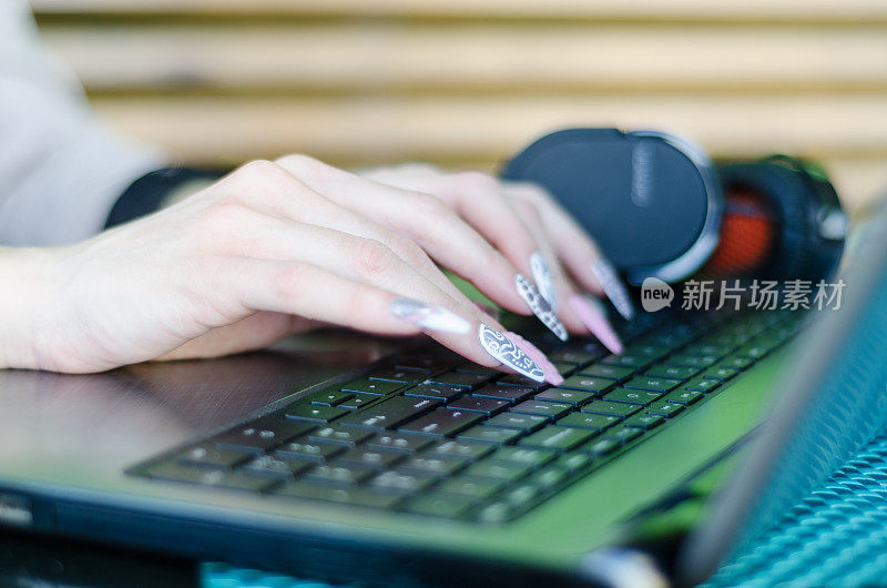 女人用长指甲敲打键盘
