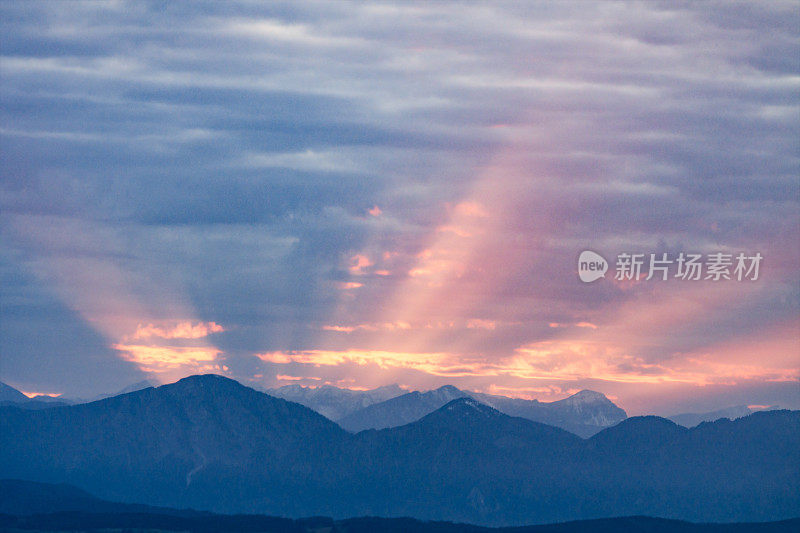 第一缕阳光升起在深蓝色的早晨阿尔卑斯山脉