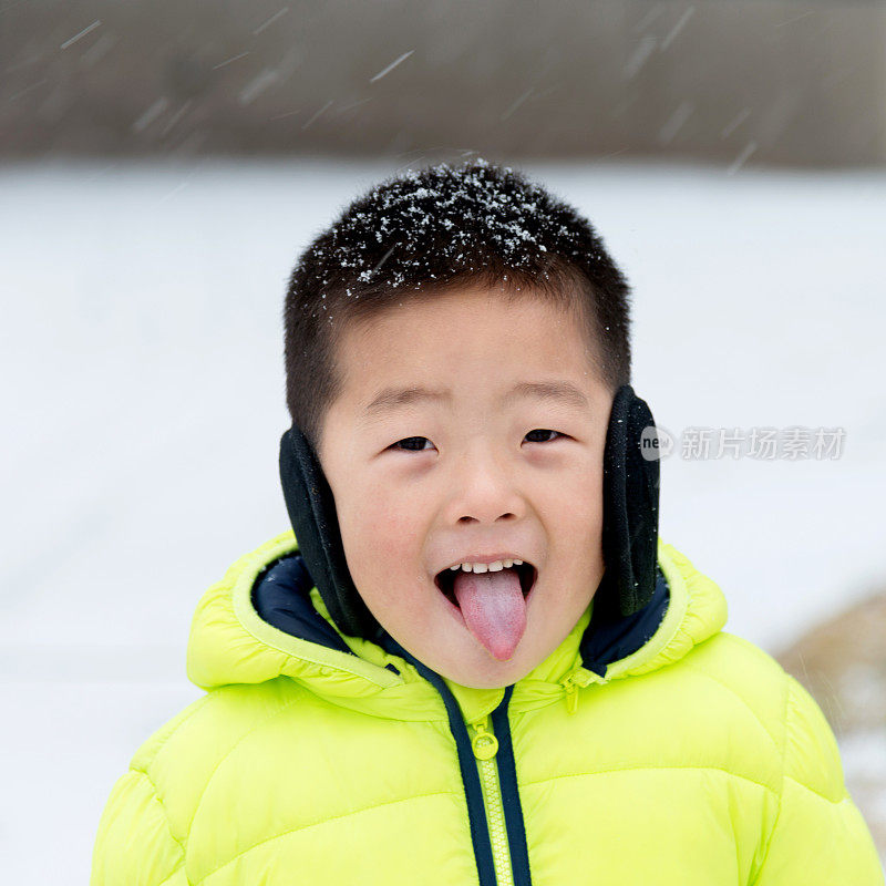 一个亚洲男孩在雪地里玩