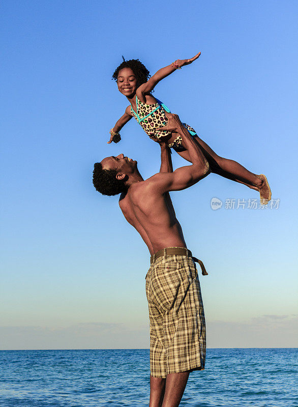 父亲在沙滩上抱着女儿