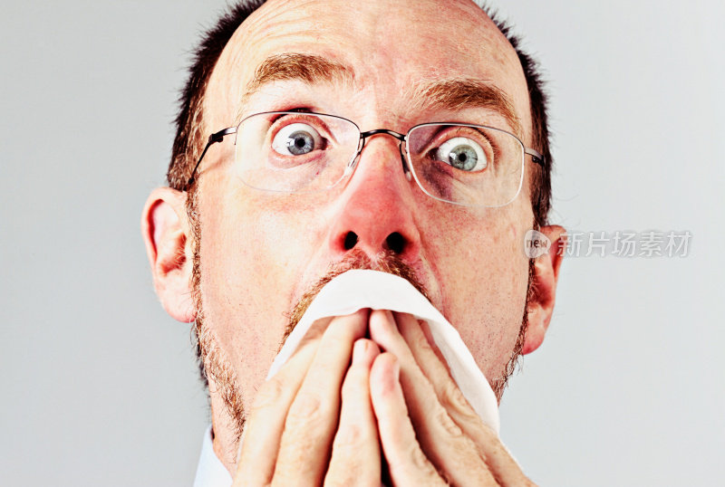 流感季节!红鼻子男人用手帕打喷嚏