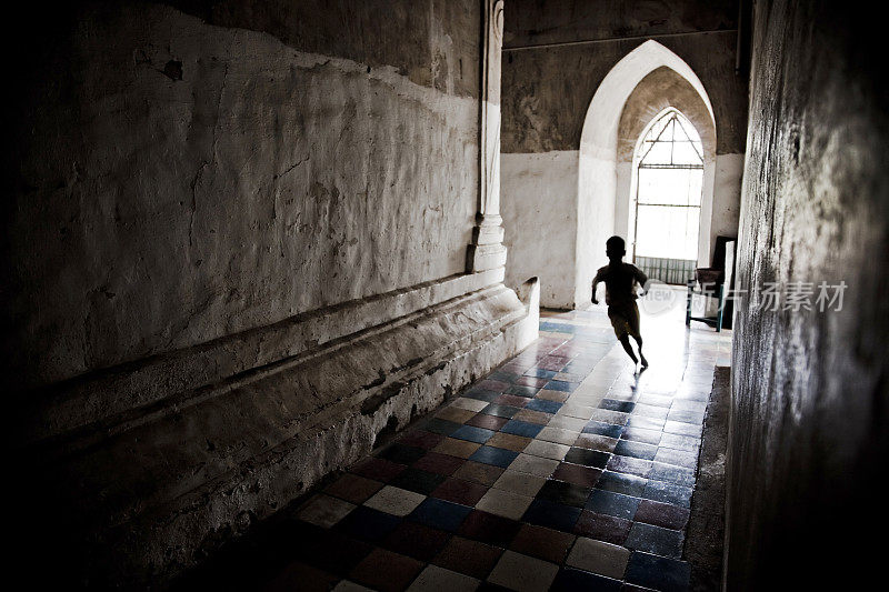 一个男孩在缅甸一座寺庙里跑步