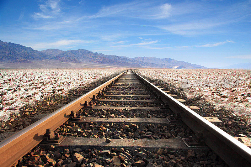 在空旷的沙漠中，铁轨一直延伸到地平线