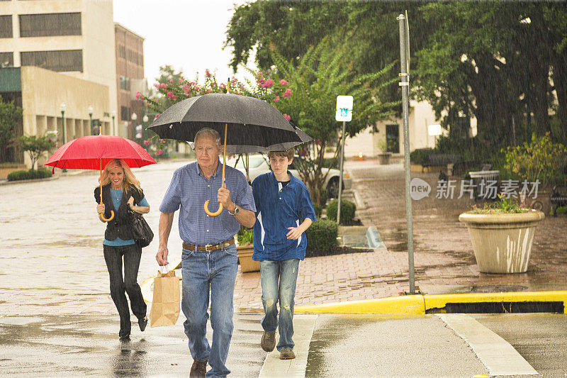 消费主义:人们在雨中购物。所有携带雨伞。