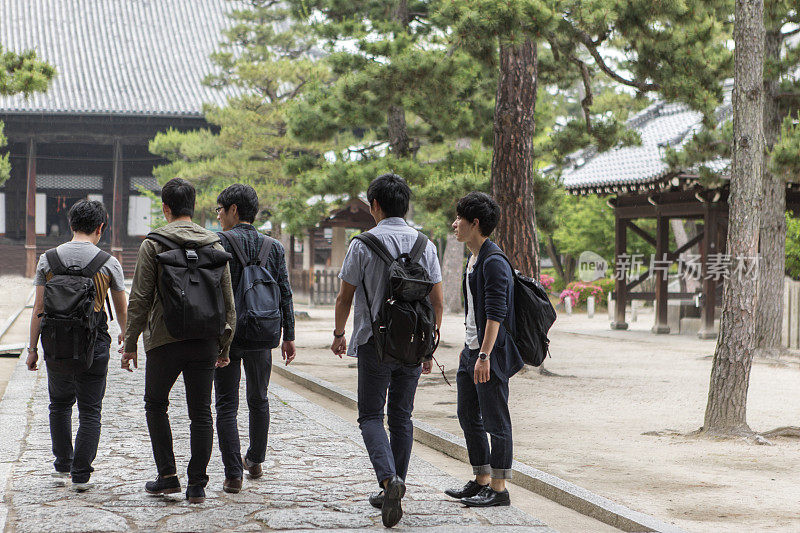 年轻的日本学生参观寺庙与朋友在日本京都