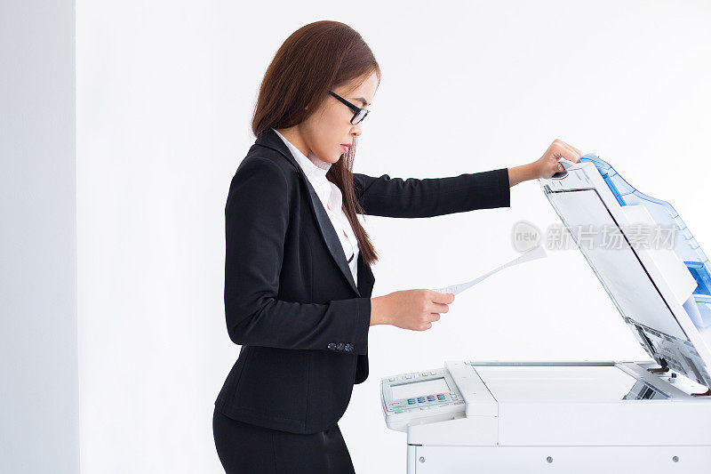 年轻的亚洲女秘书使用激光复印机
