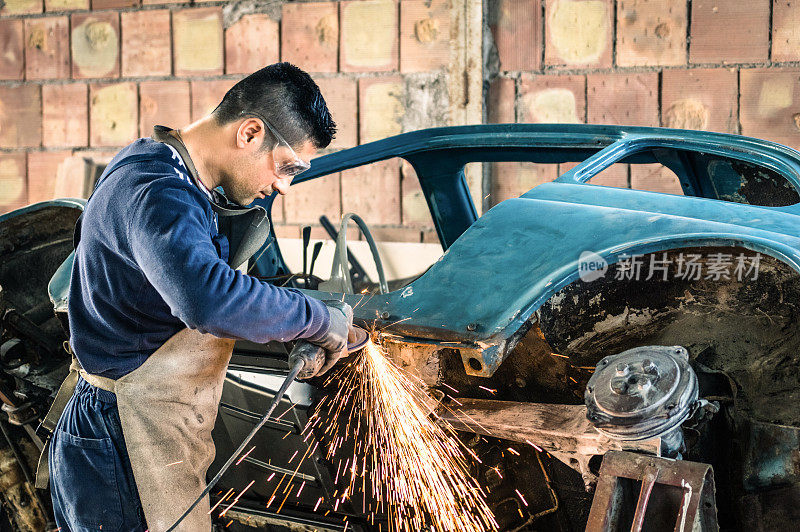 一个年轻人正在修理一辆老爷车