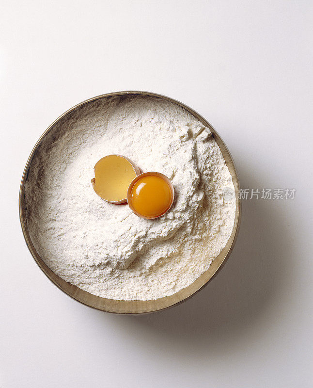 面粉和鸡蛋放在一个铜碗里